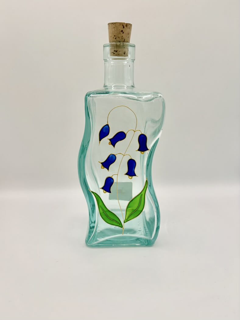 Decorative glass bottle with blue floral design on a white background