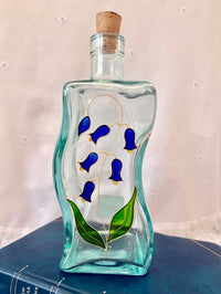 Decorative glass bottle with blue floral design on a white background