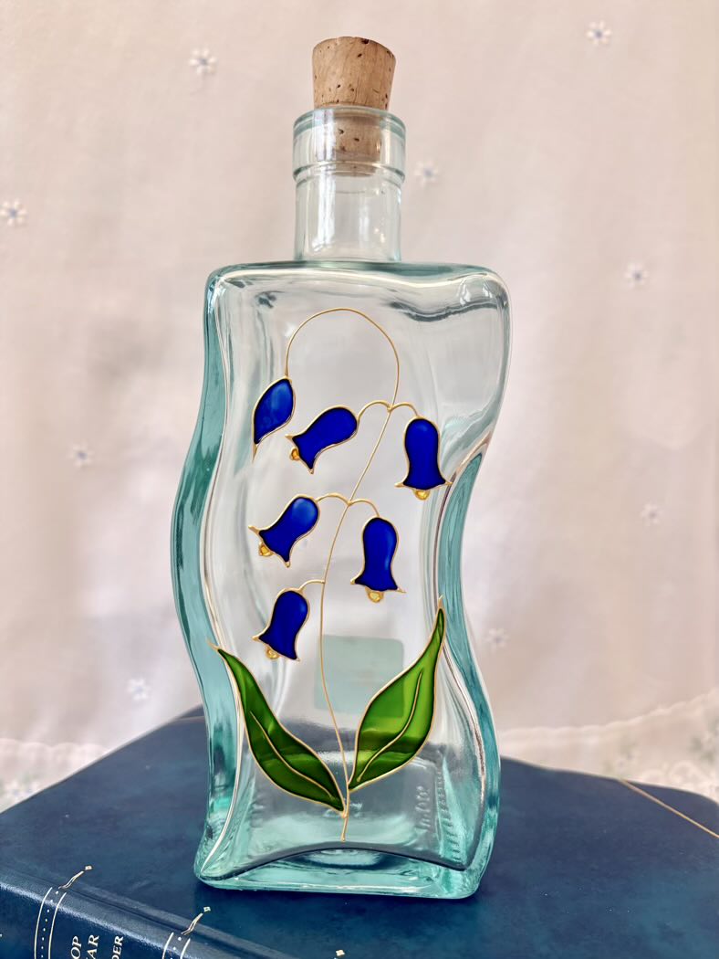 Decorative glass bottle with blue floral design on a white background