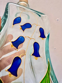 Decorative glass piece with blue and gold designs on a plain background