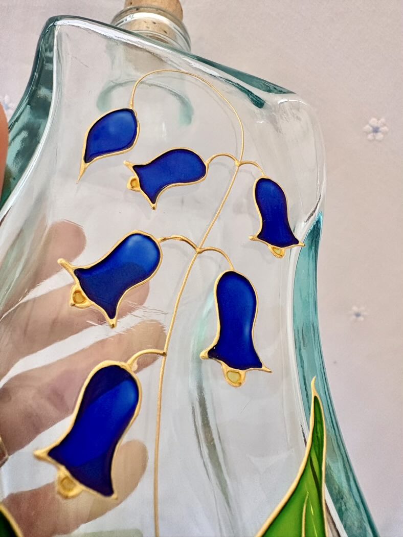 Decorative glass piece with blue and gold designs on a plain background