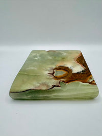 Green stone with brown and white patterns on a white background