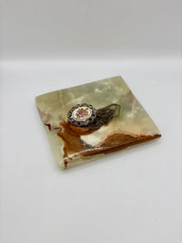 Decorative stone coaster with a decorative ring on a white background