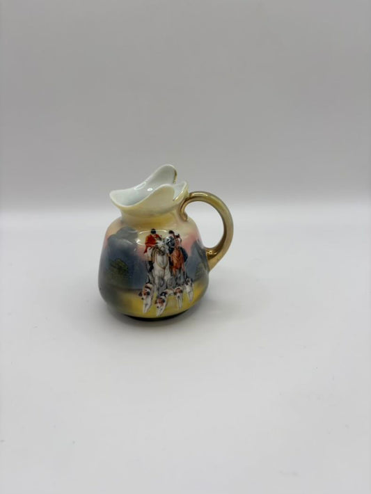 Small ceramic pitcher with horse painting on a white background