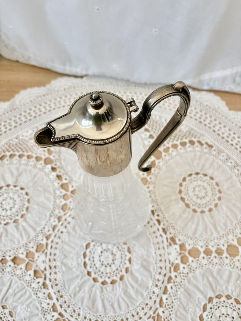Silver jug on a white lace doily