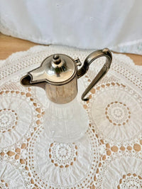 Silver jug on a white lace doily