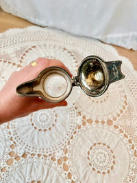 Hand holding a jug on a lace tablecloth