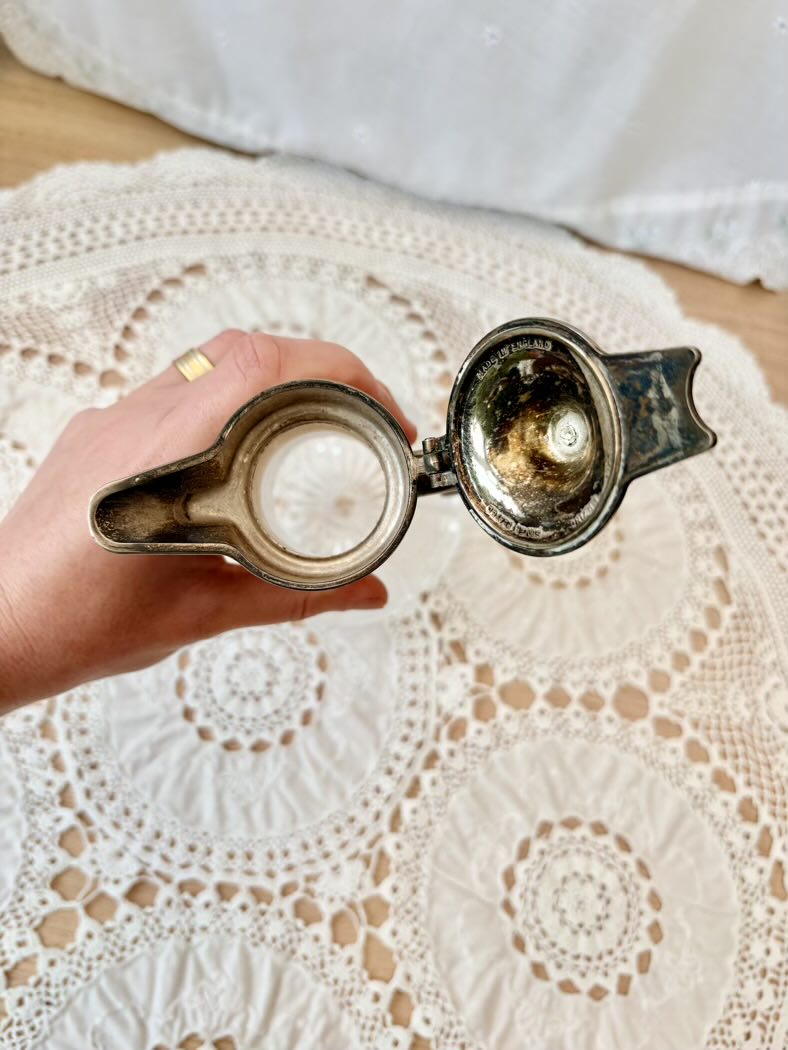 Hand holding a jug on a lace tablecloth