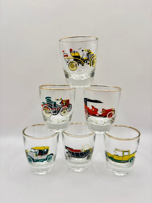 Set of six shot glasses with vintage car designs on a white background