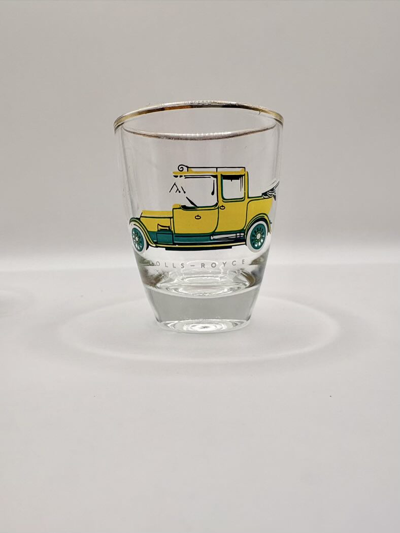 Clear shot glass with a yellow car illustration on a white background