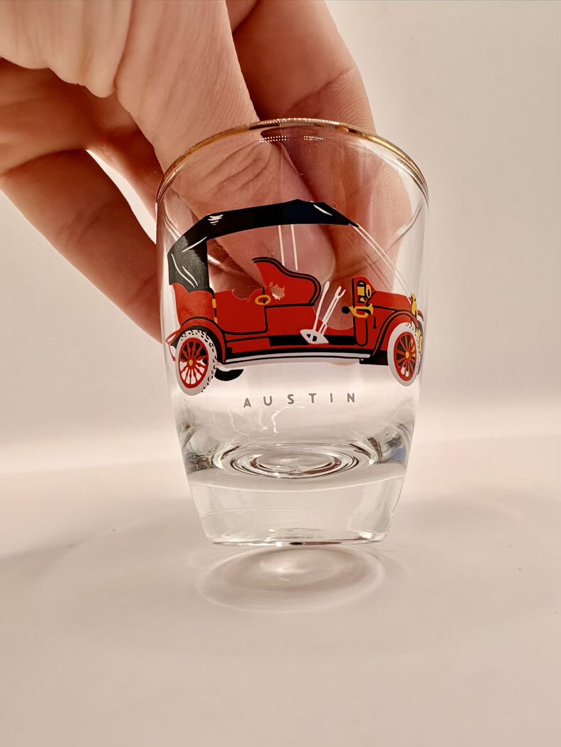 Clear glass with a red car illustration and 'Austin' text on a beige background