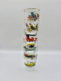 Stack of four shot glasses with vintage vehicle illustrations on a white background
