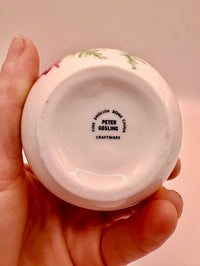 Hand holding a ceramic product with 'Peter Gosling' branding on a plain background