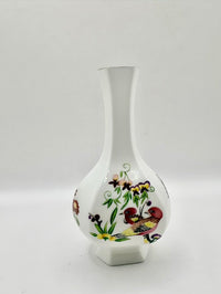 Decorative vase with floral and bird design on a white background