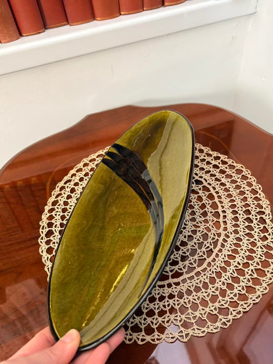 Green ceramic tray inside a box held by a hand on a lace doily