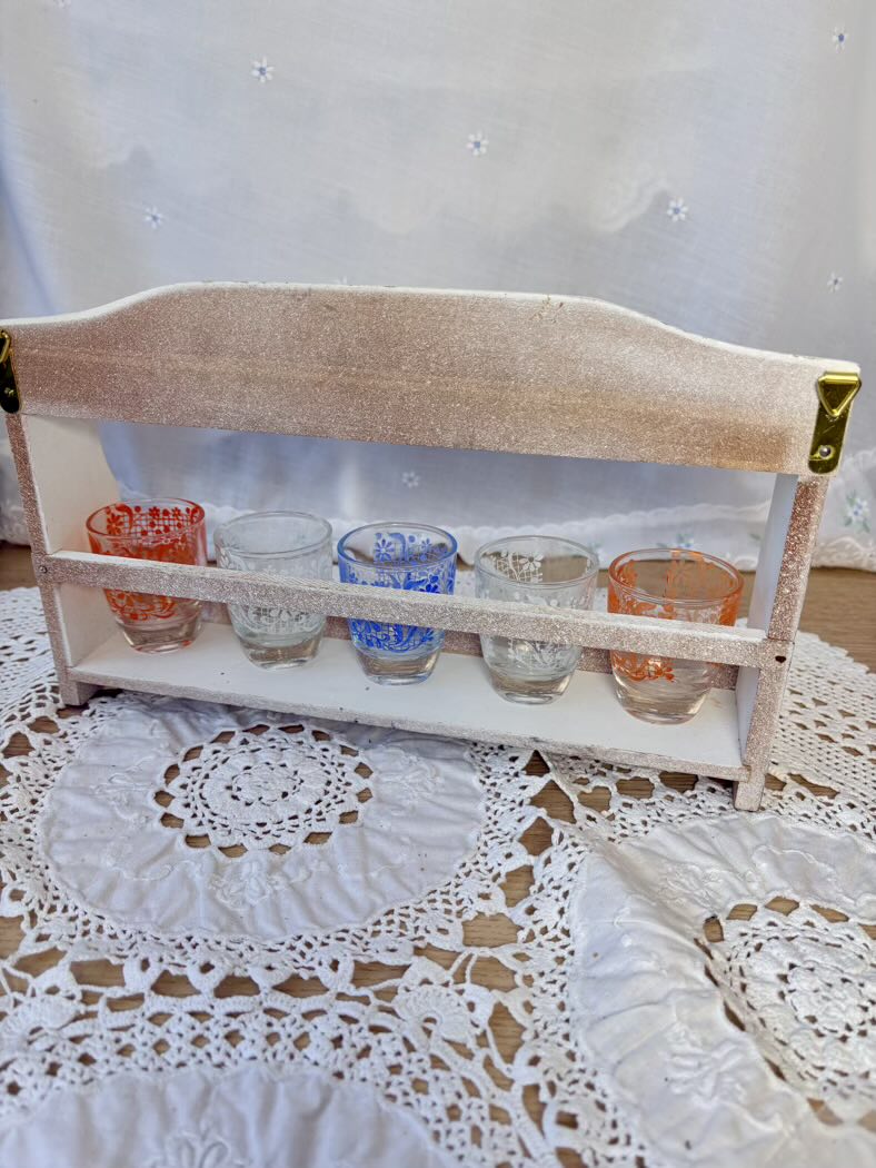 Small wooden shelf with glass containers on a lace tablecloth