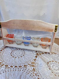 Small wooden shelf with glass containers on a lace tablecloth