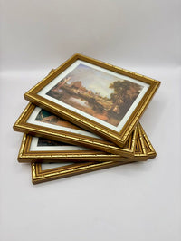 Stack of gold-framed pictures on a white background