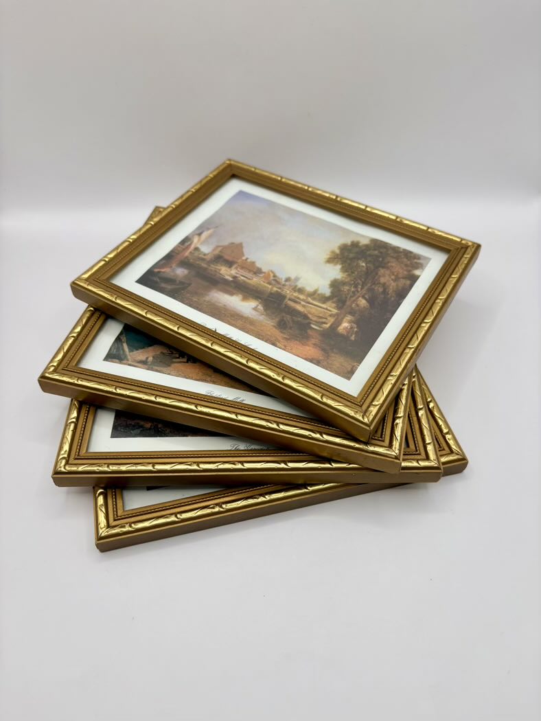 Stack of gold-framed pictures on a white background