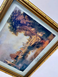 Framed painting of a landscape with trees and buildings.