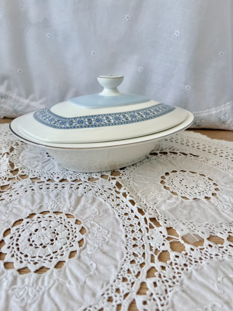 White ceramic dish with blue patterns on a lace tablecloth