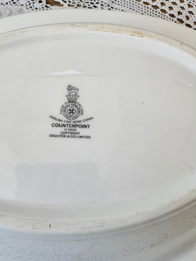 White ceramic plate with a visible brand logo and text on a textured surface.