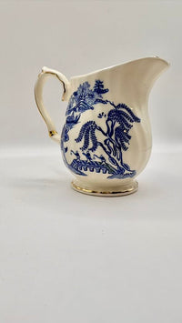 White ceramic pitcher with blue floral patterns on a light gray background