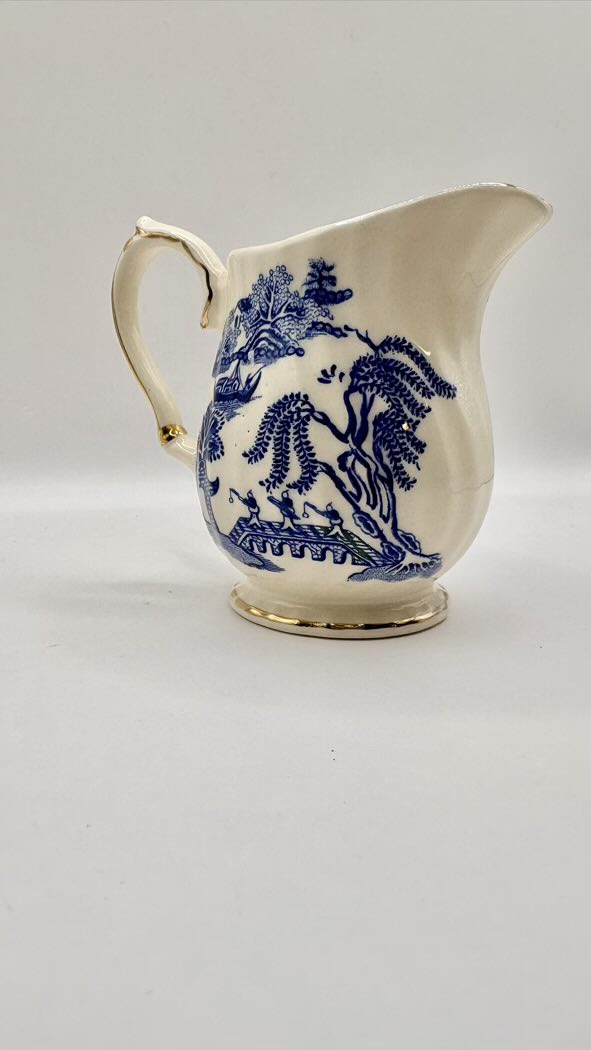 White ceramic pitcher with blue floral patterns on a light gray background