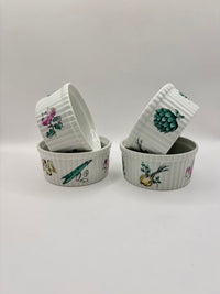 Set of four ceramic ramekins with botanical illustrations on a light gray background