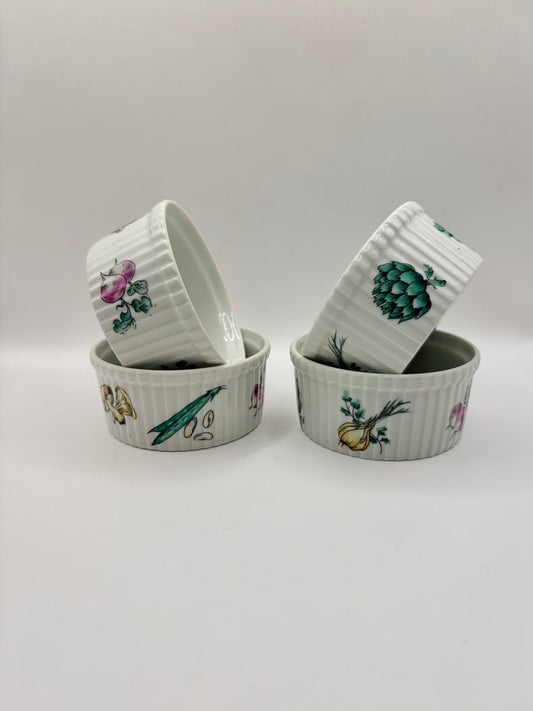 Set of four ceramic ramekins with botanical illustrations on a light gray background