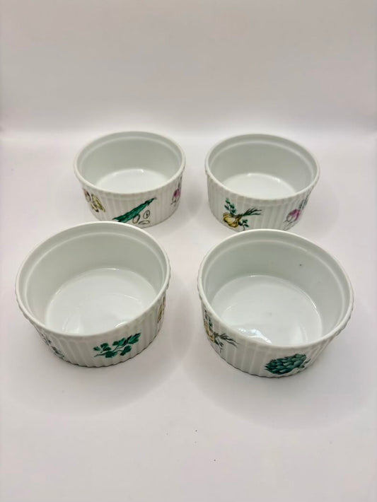 Four small ceramic ramekins with floral patterns on a white background