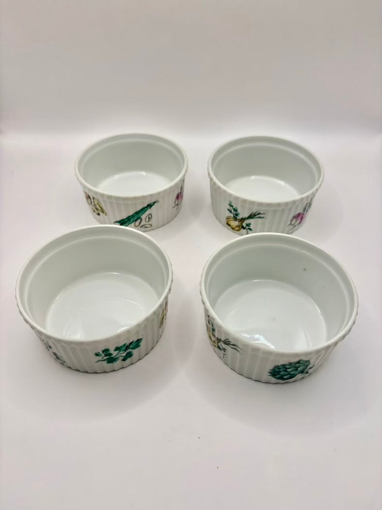 Four small ceramic ramekins with floral patterns on a white background