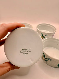 White ceramic lid with 'Apilco' branding held by a hand against a light background.