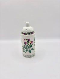 Ceramic jar with floral design on a white background