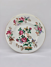 Decorative plate with floral and butterfly design on a plain background