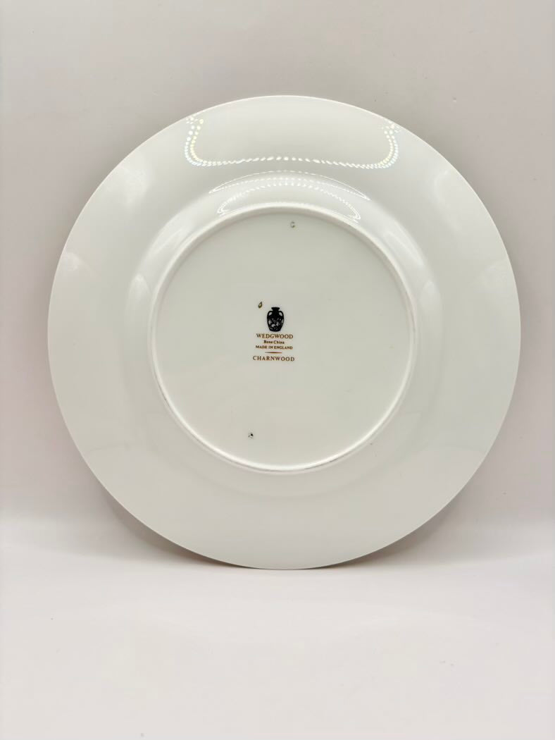 White ceramic plate with a visible brand logo on a light gray background