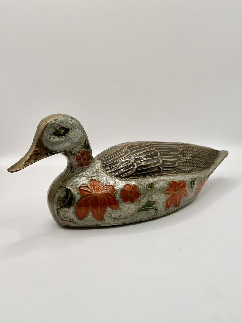 Decorative duck-shaped object with floral patterns on a white background