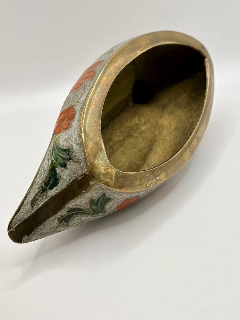 Decorative brass container with painted design on a white background