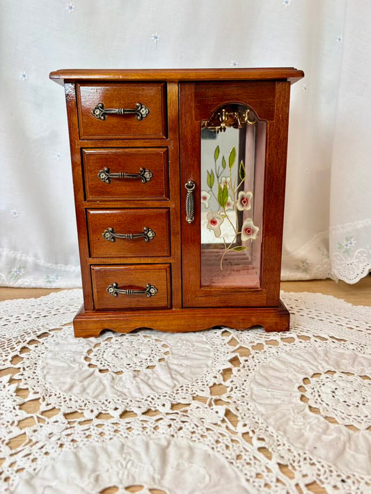 Wooden jewelry cabinet with mirror on a lace tablecloth