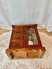 Wooden jewelry box with glass lid on a lace tablecloth