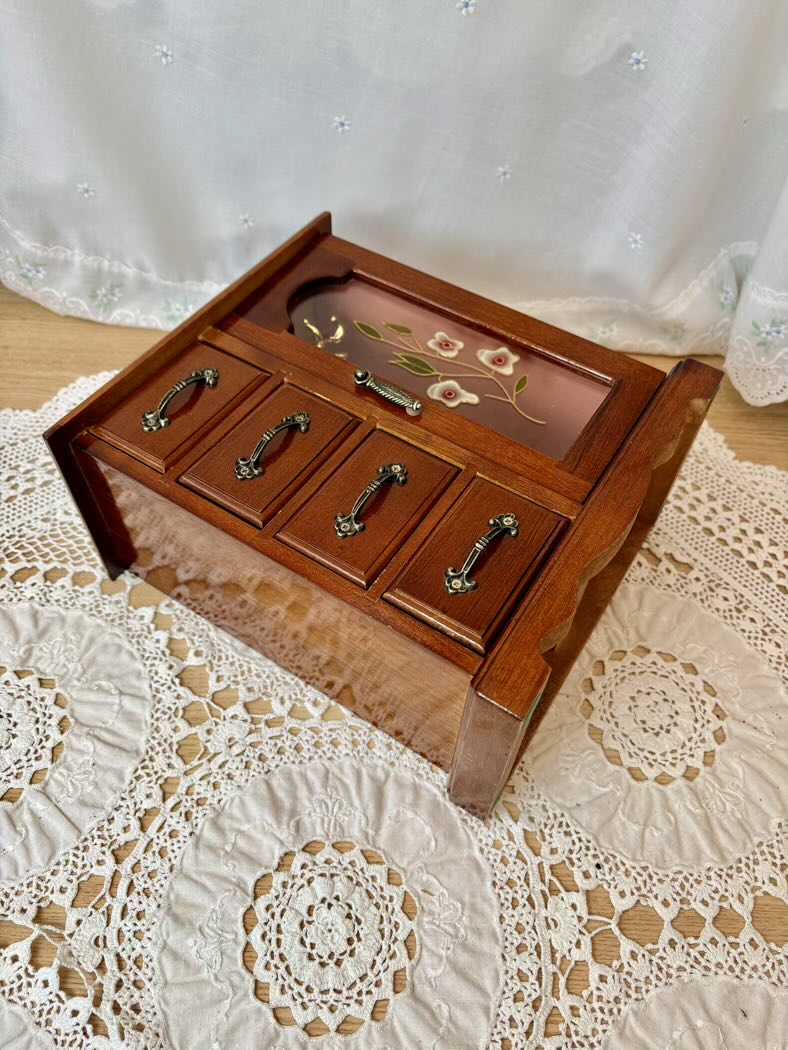 Wooden jewelry box with floral design on a lace tablecloth