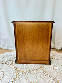 Wooden box on a lace tablecloth with a white curtain background