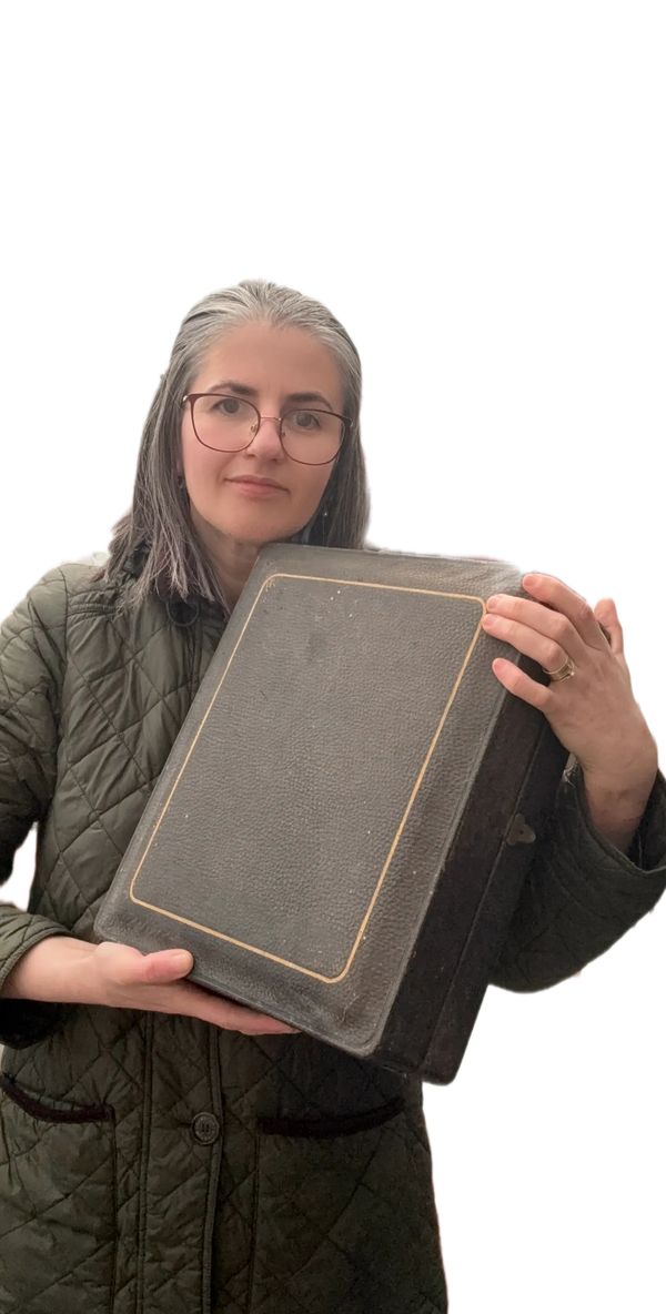 Person holding a rectangular gray object against a white background