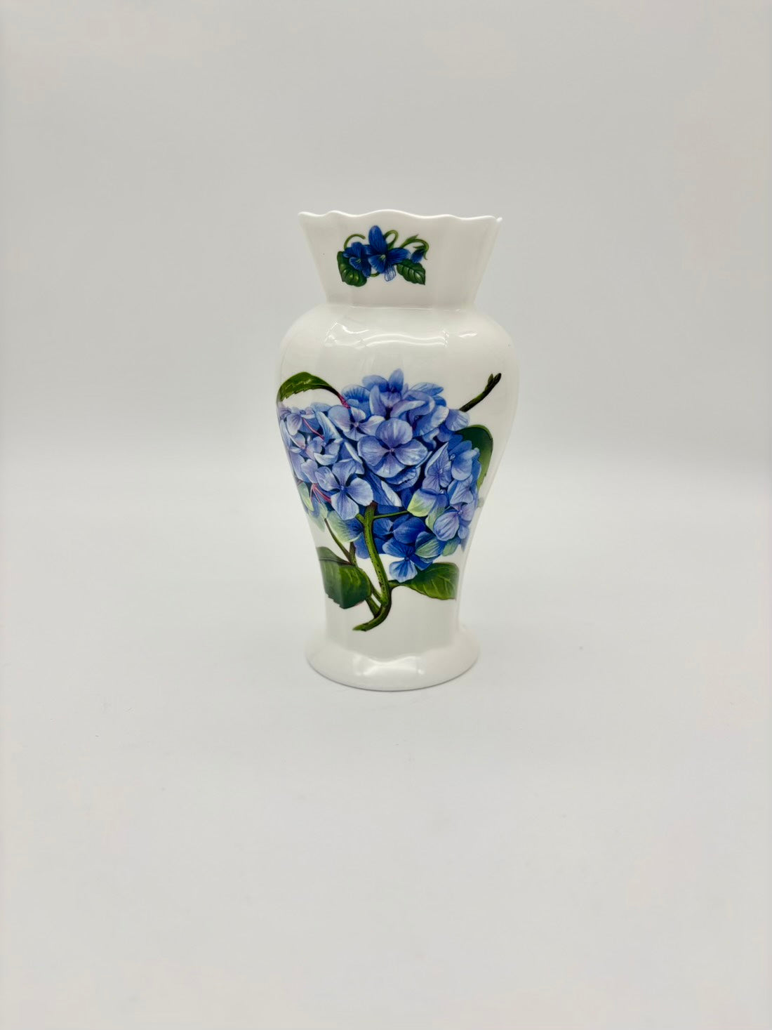 White ceramic vase with blue floral design on a white background