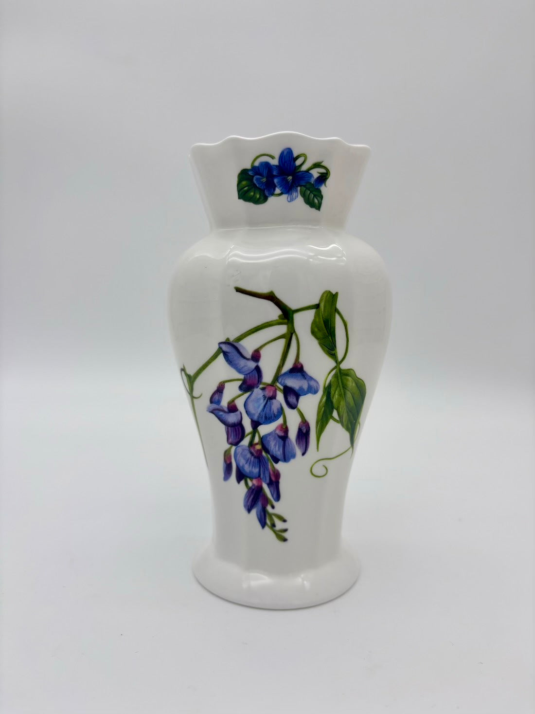 White ceramic vase with floral design on a white background
