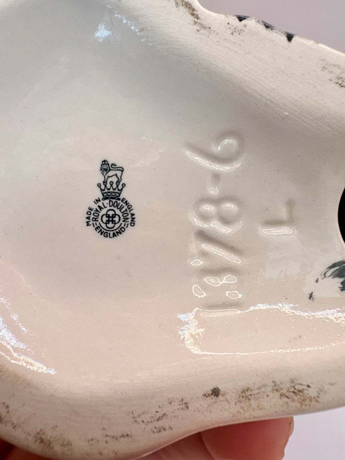 Close-up of the inside base of a glossy white ceramic plate or dish, showing embossed '1378-6' and a black Royal Warrant mark with a crown and cross.