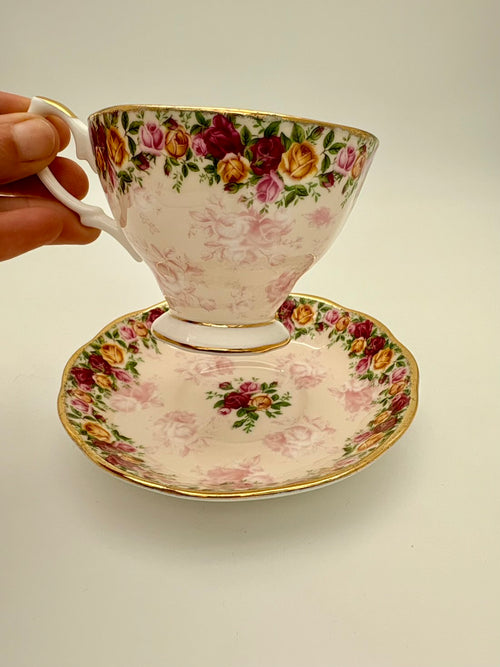 Decorative teacup and saucer with floral pattern on a plain background