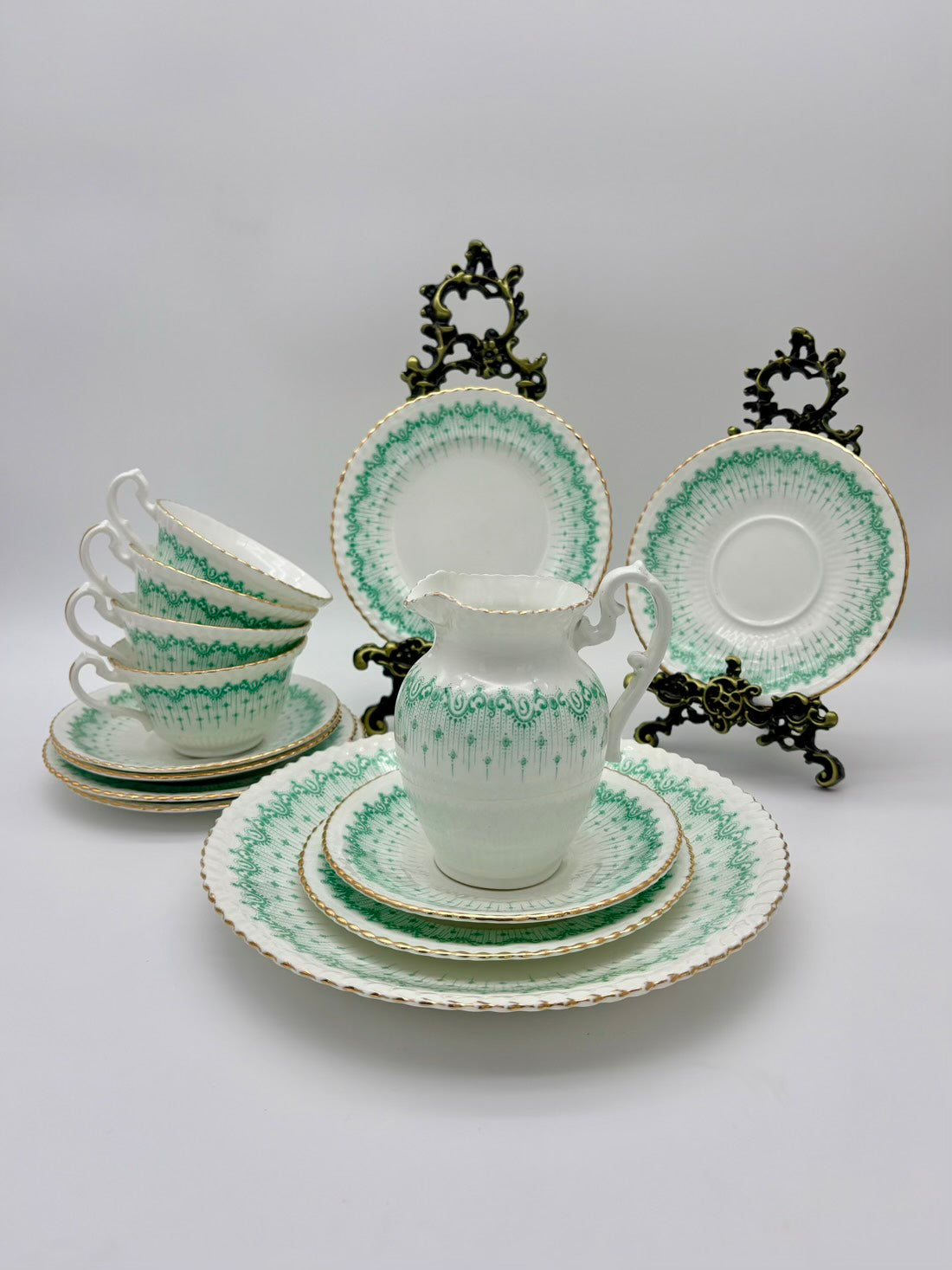 Set of white ceramic tea set with green patterns on a gray background