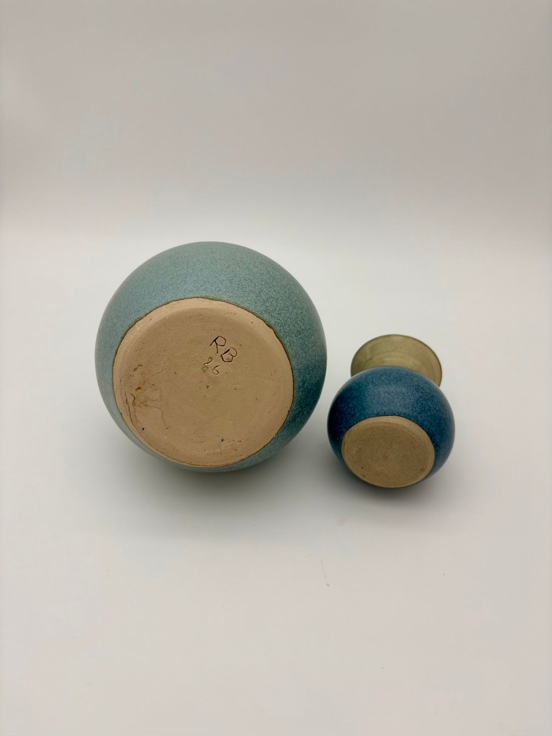 Two ceramic containers with textured surfaces on a white background