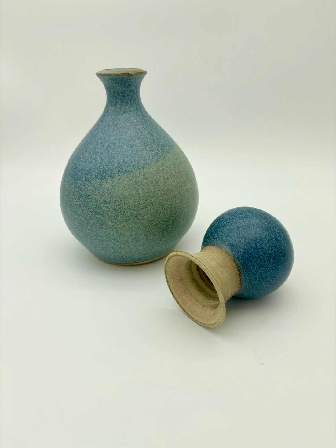 Two ceramic vases with a gradient blue finish on a white background